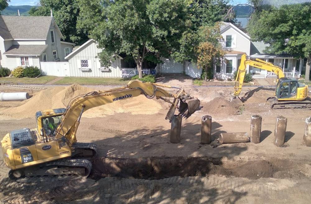 A backhoe digging up a street