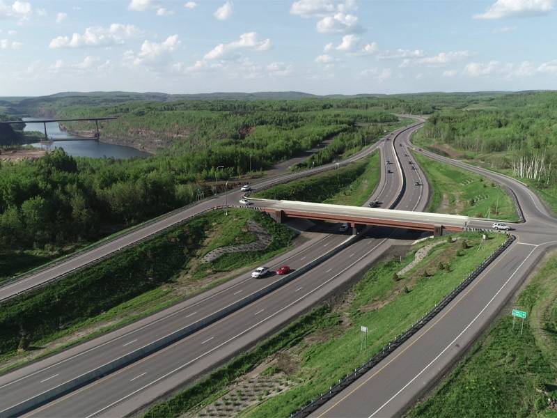 Landscape of roadway and bridges with a river and trees